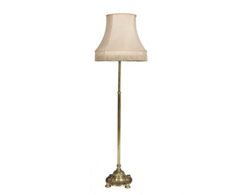 A CAST BRASS TELESCOPIC EXTENDING STANDARD LAMP, the plain fluted column rising from a spreading circular weighted base on bu