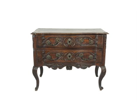 A 19TH CENTURY FRENCH PROVINCIAL FRUITWOOD SERPENTINE FRONT COMMODE, the moulded top above twin drawers carved with scrolls a