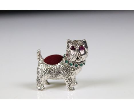 Silver pincushion in the form of a dog with ruby eyes and emerald collar 