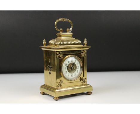 An antique brass cased carriage clock with Fluer De Lis decoration, marked for Lund &amp; Blockley of London. 