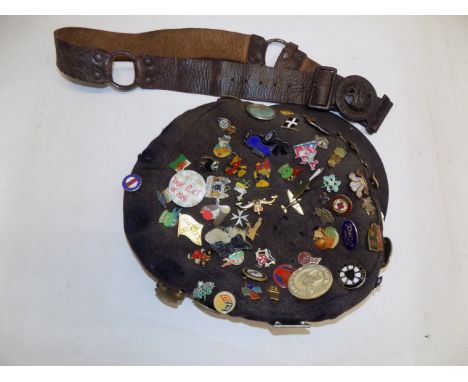 A cap with many enamel and other badges, together with a scout belt.