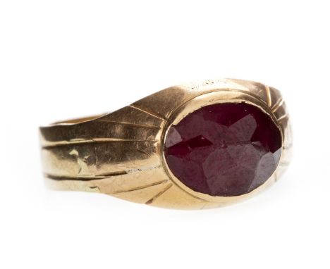 RED GEM SET SIGNET STYLE RING, set with a single oval faceted red gem 9.5mm long, with engraved linear decoration to the shou