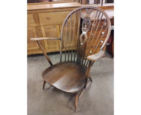 An Ercol Golden Dawn elm and beech fleur de lys armchair 