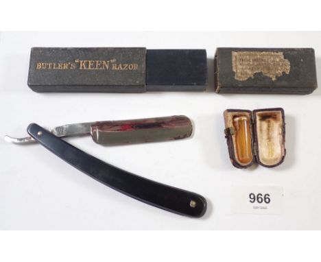 An amber cheroot with yellow metal rim - cased and a cut throat razor 'Butlers Keen' 
