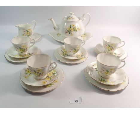 A Royal Albert Primrose tea service comprising five cups and saucers, teapot, cake plate and milk jug