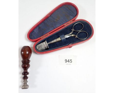 A cased pair of needlework scissors with silver thimble and a wooden handled white metal seal 