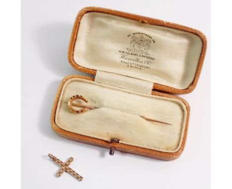 An 18 carat gold horseshoe stick pin 2.3g - boxed and a 9 carat gold crucifix 0.6g 