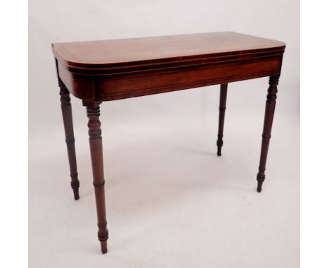 An early 19th century mahogany fold top card table with satinwood and ebony stringing, all on turned supports