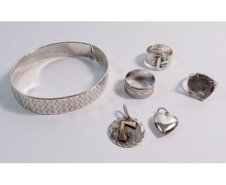 A silver bangle and various silver rings, heart pendant etc.