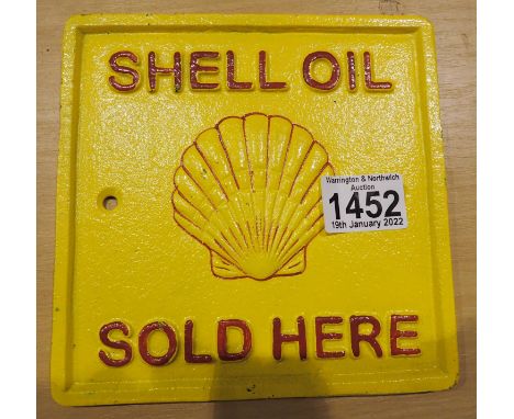 Cast iron Shell oil sold here wall sign, L: 17 cm. P&amp;P Group 2 (£18+VAT for the first lot and £3+VAT for subsequent lots)