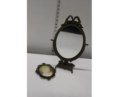 A brass table top mirror and photo frame 