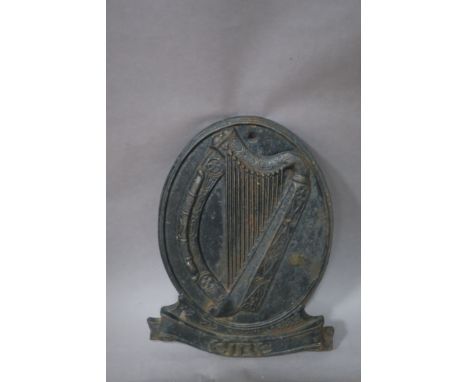 AN OVAL CAST IRON WALL MOUNTED "EIRE" PLAQUE, depicting a celtic harp,54cms x 41cms.