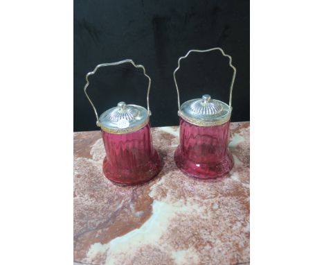A PAIR OF RUBY GLASS AND CHROME JARS WITH SWING HANDLES