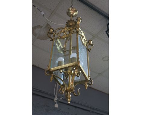 A GEORGIAN STYLE BRASS FRAMED FOUR LIGHT HALL LANTERN, the rectangular bevelled glazed panels headed by an openwork frieze, d