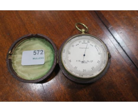 A LEATHER CASE BAROMETER, the brass frame with a clear glass face revealing a silvered dial engraved "C Comitti, & Son Ltd. L