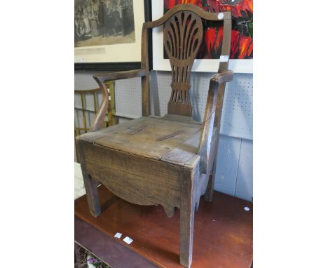 A GEORGIAN COMMODE, with pierced splat above a hinged seat on square moulded legs.
