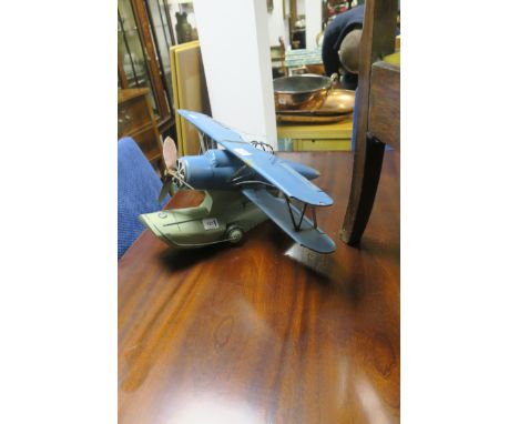A BLUE AND GREEN PAINTED METAL MODEL OF AN EARLY SEA PLANE, with moving propeller.