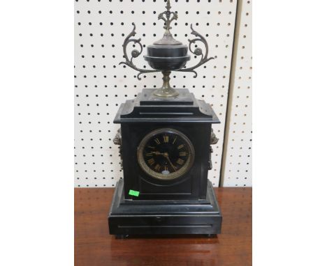 A VICTORIAN BLACK MARBLE MANTLE CLOCK of rectangular form the stepped top headed by a brass mounted classical urn above the b