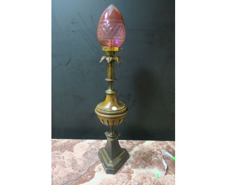 A REGENCY STYLE GILT BRASS AND FAUX TABLE LAMP of circular tapering form headed by a cut glass ruby shade on triangular plint