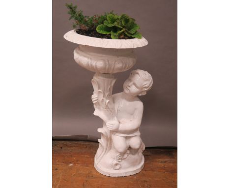 A WHITE PAINTED CAST IRON FIGURAL PLANTER modelled as a young child holding a loft a circular bowl with gadrooned rim on oval