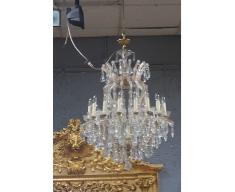 A CONTINENTAL CUT GLASS SIXTEEN LIGHT CHANDELIER, with circular corona and reservoir issuing inverted scrolled arms headed by