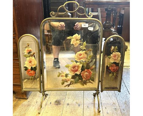 An early 20th century painted mirror triptych fire screen, in a brass frame 