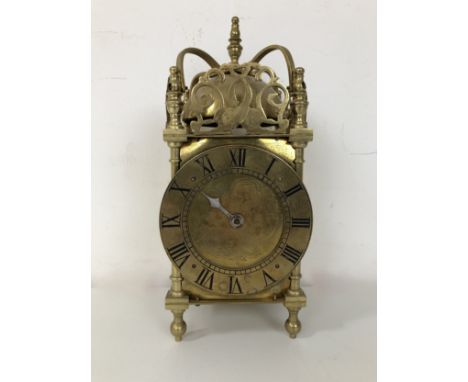 A lantern clock, in a brass case, 20 cm high 