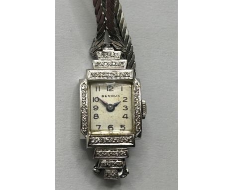 A ladies white gold and diamond Benrus cocktail wristwatch, on a later strap, and a 19th century garnet ring (2)Ring band mis