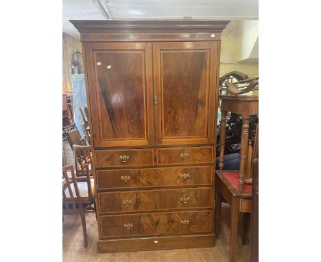 A mahogany linen press, the top with two cupboard doors, on a base with two short and three graduated long drawers, and a set