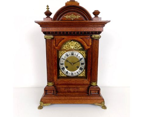 A mantel clock, the brass dial with a silvered chapter ring, in an oak case, 56 cm high 