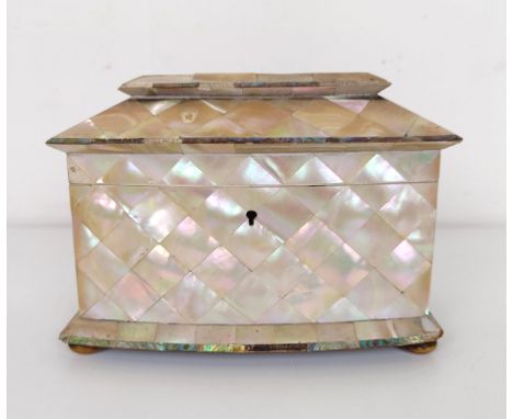 A mother of pearl veneered tea caddy, the lid to reveal two caddies, 20 cm wideThe ivory handles of the caddy tops have been 