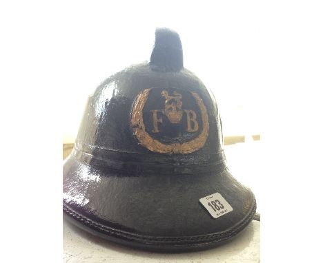 A leather fireman's helmet bearing FB Crest to front.