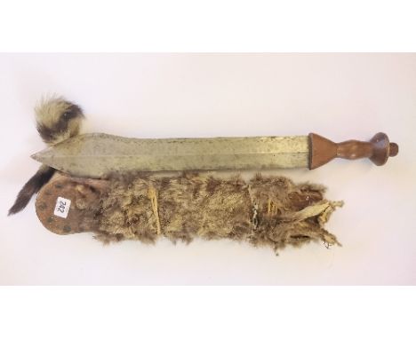 An African short sword in fur covered wooden scabbard. Brought back from the Belgium Congo by U.N Officer.