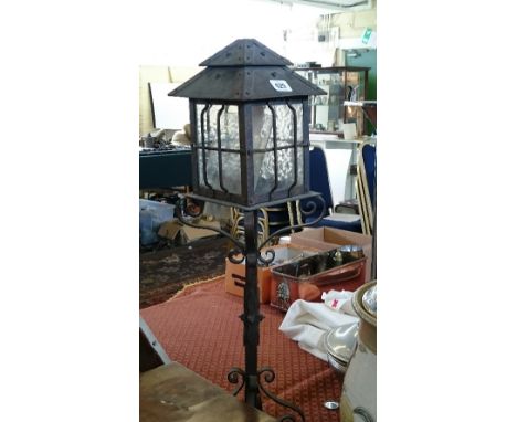 An Arts & Crafts style wrought iron lantern table lamp.