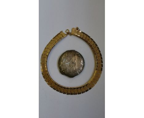 An engine turned silver powder compact together with a gold metal choker.