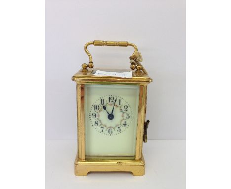 An early 20th century brass and glass cased French carriage clock with enamel decorated dial (appears working).