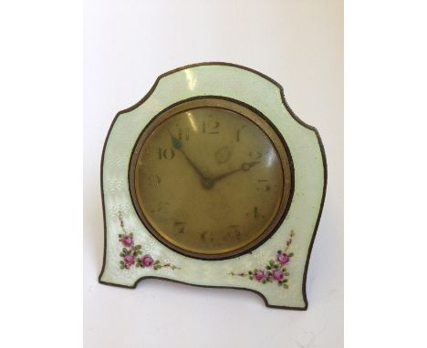 An early 20th century enamel framed bedside mantle clock decorated with sprays of pink roses.