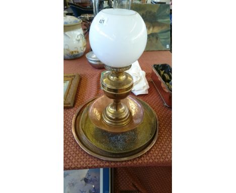 A brass oil lamp together with three copper and brass items.