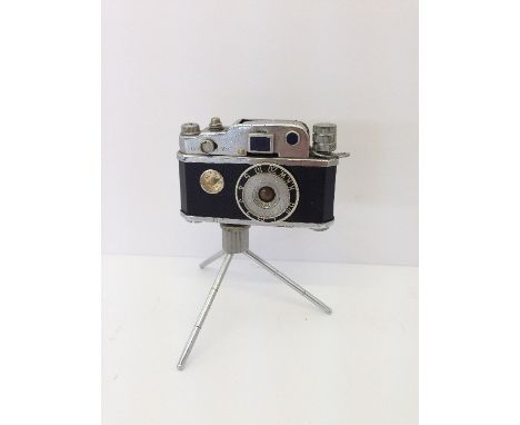 A miniature KKW camera cigarette lighter on tripod stand.