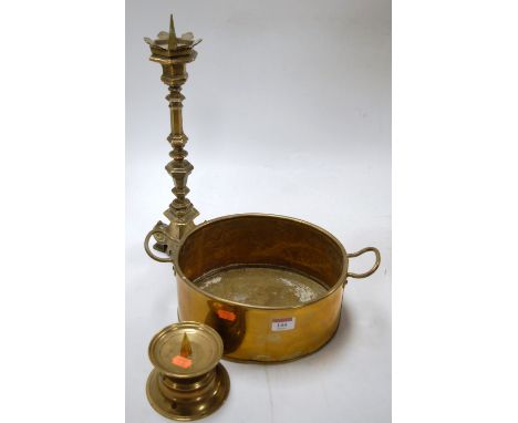 A 20th century brass twin handled pan together with a brass pricket style candlestick and one other smaller example (3)