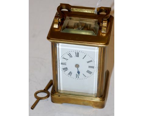 A 20th century lacquered brass cased carriage clock, having enamelled dial with Roman numerals and visible platform lever esc