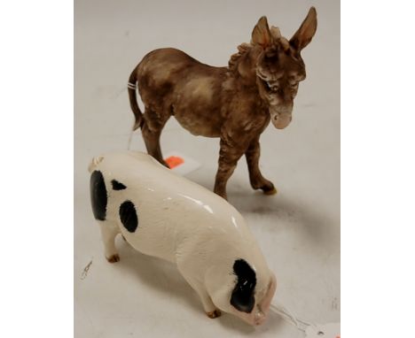 A Kaiser bisque model of a donkey, height 17cm, together with a Royal Doulton figure of a spotted pig (2)