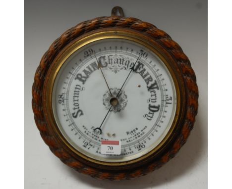 A late Victorian aneroid barometer, the circular enamel dial housed in a carved oak ropetwist surround; together with one oth