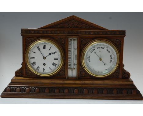 A late Victorian carved oak cased clock barometer, having central thermometer flanked by clock with further barometer, the ca