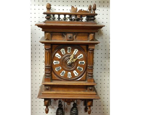 A late 19th century Continental oak cased wall clock, having convex enamel markers with Roman numerals and twin weight driven