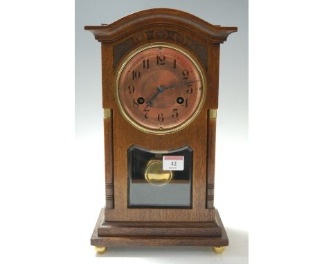 A late 19th century carved oak mantel clock, having a brass dial with Arabic numerals and eight day movement striking on a go