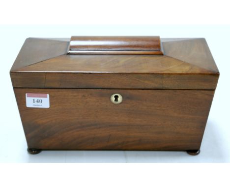 A circa 1830 mahogany tea caddy of sarcophagus form having a twin compartment interior and central glass mixing bowl, on squa