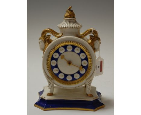 A late 19th century German porcelain cased mantel clock, having gilt Roman numerals, flanked by gilt heightened rams head mas