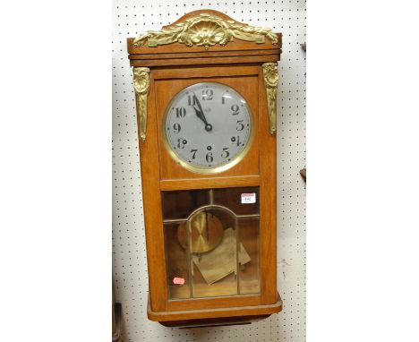 A circa 1900 Continental oak cased and gilt metal mounted wall clock having a silvered dial with Arabic numerals and chiming 