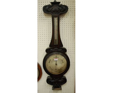 An Art Nouveau carved oak cased wheel barometer, the silvered dial signed Chadburns Ltd, Opticians of Liverpool (losses to ca